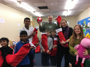 Trevor with young school pupils having just received their donated stockings.
